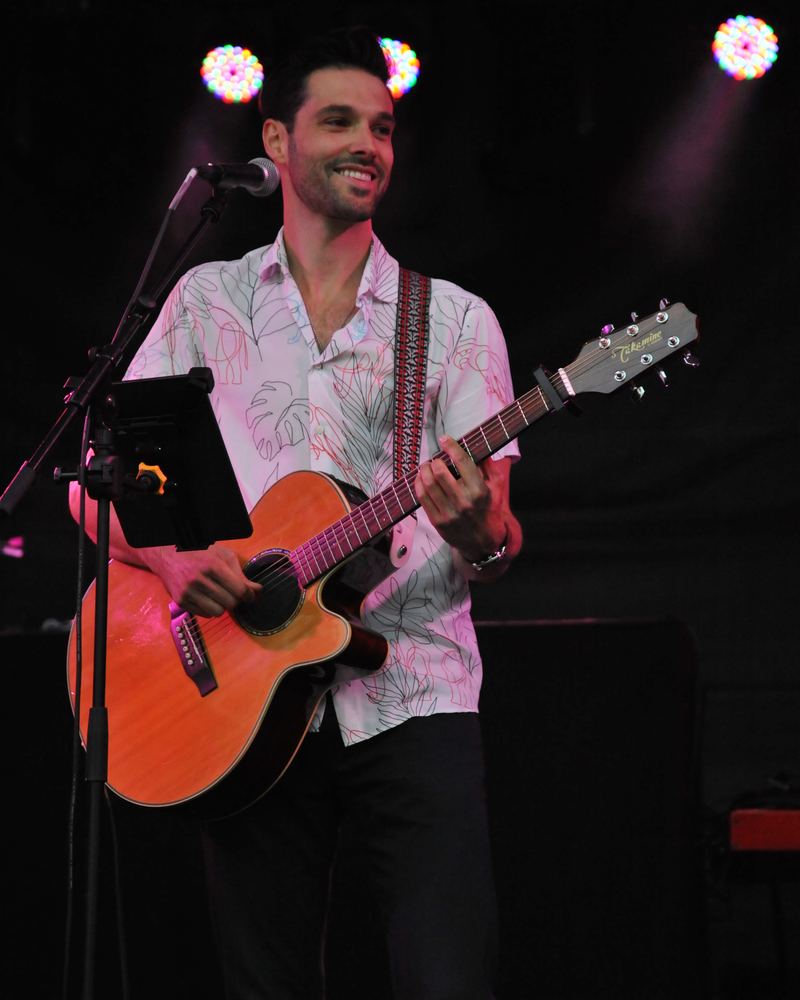 Yann sur scène, souriant, guitare à la main